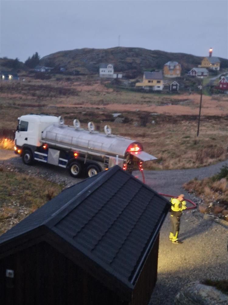 tankbil med drikkevatn ved nokre hus - Klikk for stort bilete