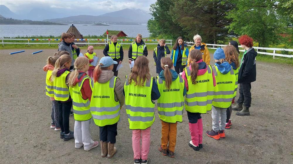En gruppe barn og voksne ute på gården - Klikk for stort bilete
