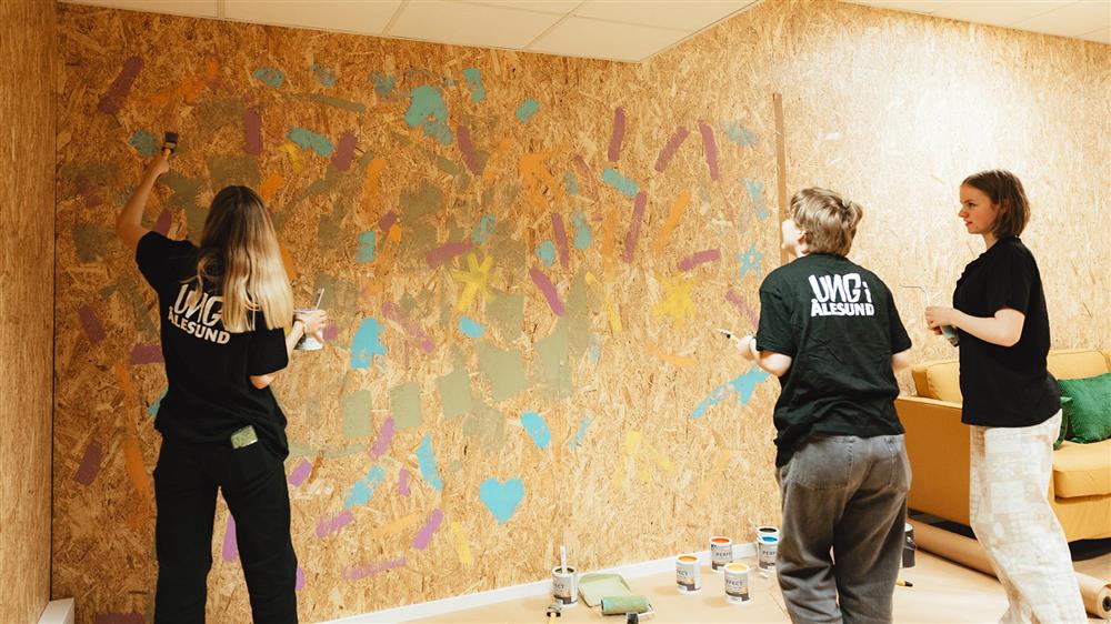 Tre ungdommer maler vegg - Klikk for stort bilete
