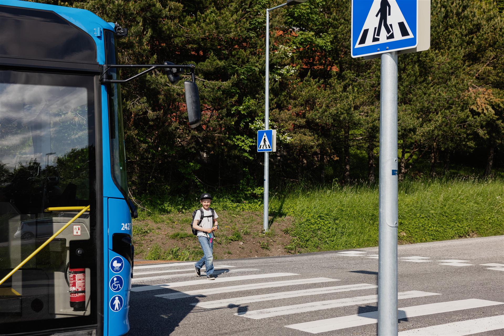 Barn går over overgangsfelt foran buss