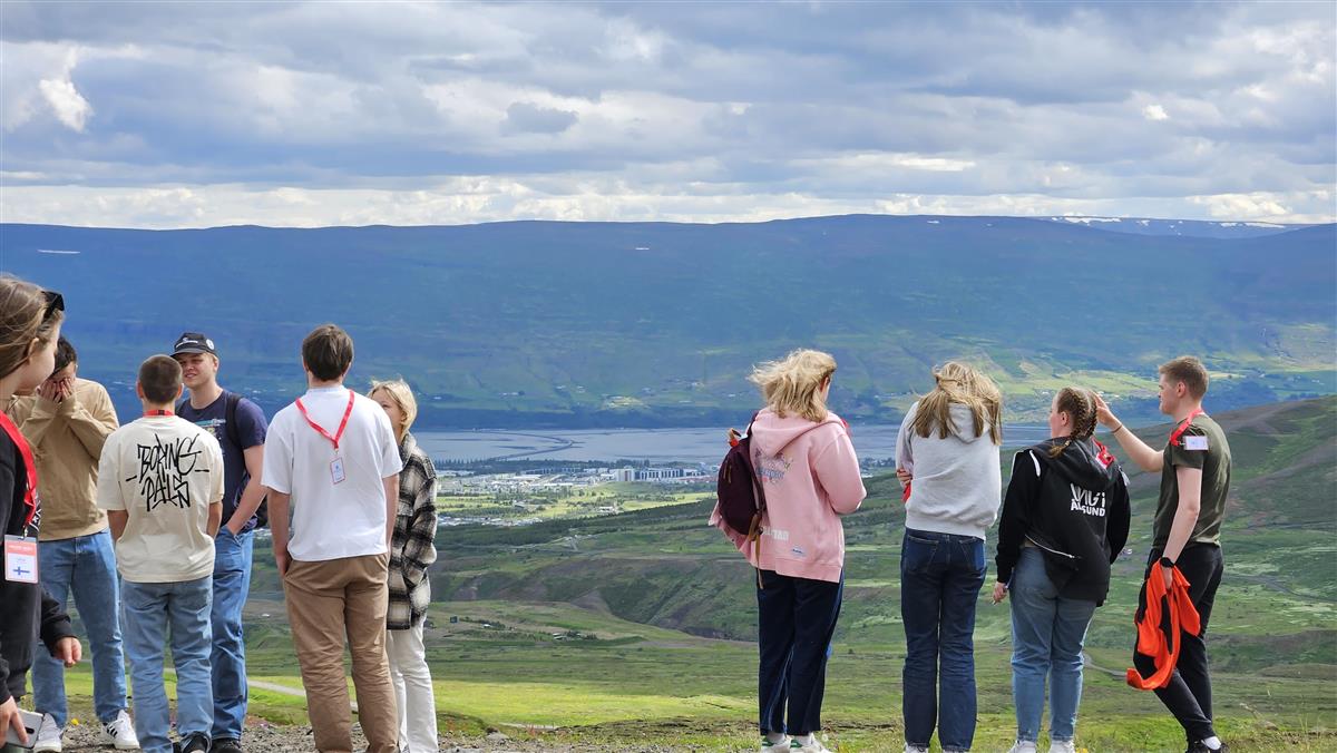 Foto av flere ungdommer med fjell og utsikt i bakgrunnen - Klikk for stort bilete