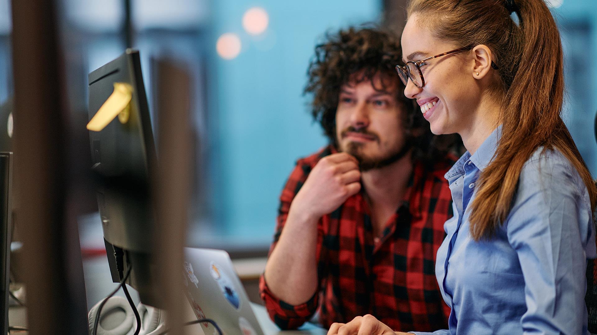 Eit par ser på ein dataskjerm.