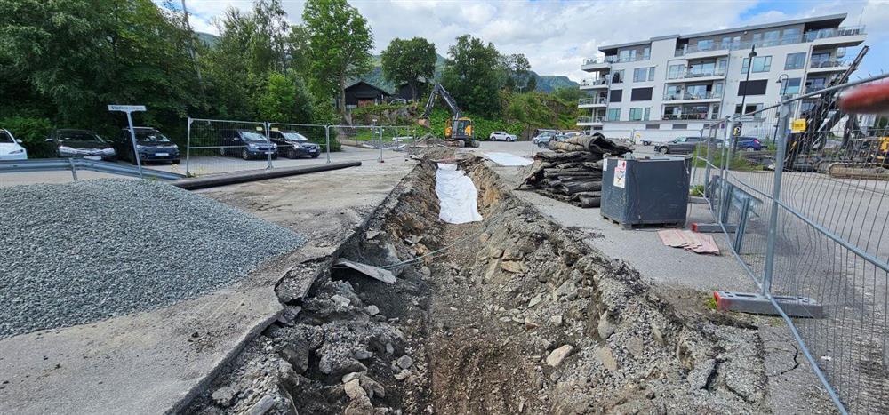 grøft med bustadblokk i bakgrunnen - Klikk for stort bilete