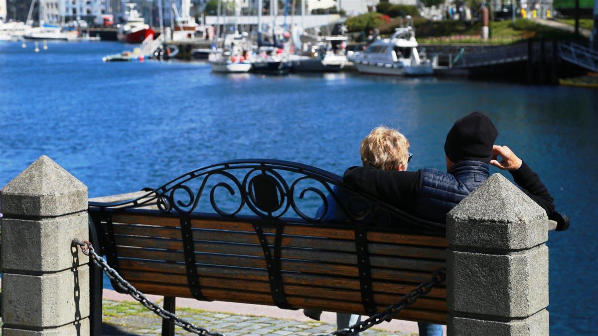 Et par som sitter på en benk ved Brosundet - Klikk for stort bilete